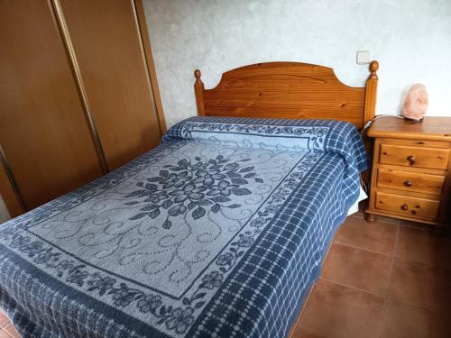 a bedroom with a bed with a blue and white bedspread at Shivanda, Habitaciones en Centro de Bienestar en la Naturaleza in Pioz
