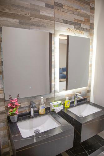 a bathroom with two sinks and two mirrors at استراحة غريس in Jeddah