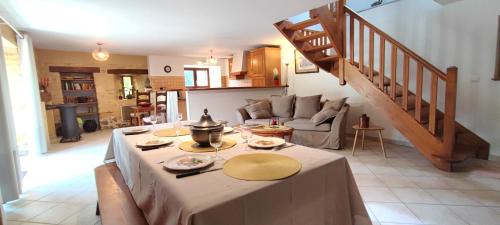 un salon avec une table et un escalier dans l'établissement Magnolia Dou-Vi, à Sarlat-la-Canéda
