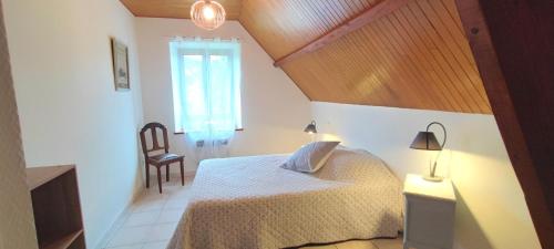 une chambre avec un lit, une chaise et une fenêtre dans l'établissement Magnolia Dou-Vi, à Sarlat-la-Canéda