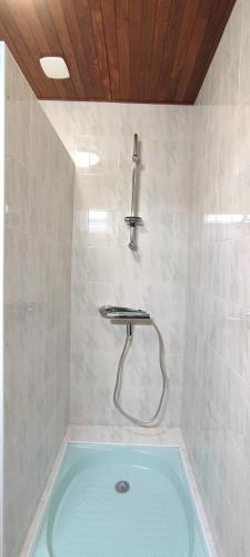 La salle de bains est pourvue d'une douche et d'une baignoire bleue. dans l'établissement Magnolia Dou-Vi, à Sarlat-la-Canéda