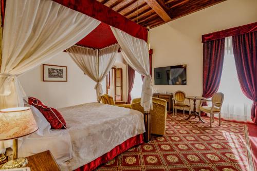 a bedroom with a bed and a table and chairs at Villa Lecchi Hotel Wellness in Colle Val D'Elsa