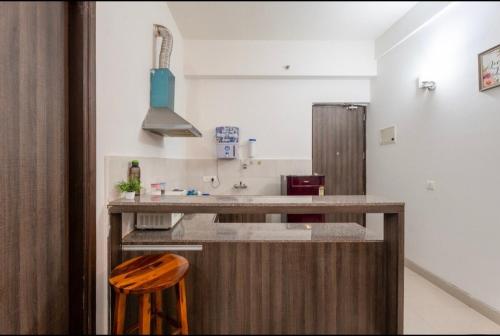 a kitchen with a counter and a wooden stool at The Label Stay Skyscraper in Gurgaon