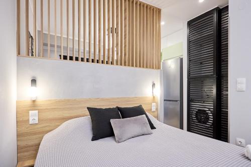 a bedroom with a white bed with black pillows at YK_Urban_Euphoria in Chios