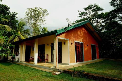 a small orange and white house with a yard at Rose Villa by Kananke Hills in Kananke