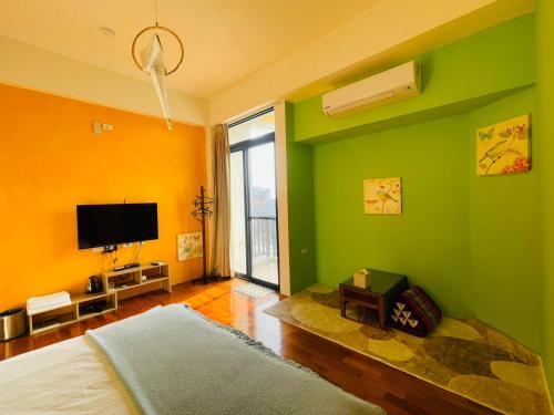 a bedroom with green and yellow walls and a television at 198紅帽民宿l市區l2025冷氣全面換新 in Magong