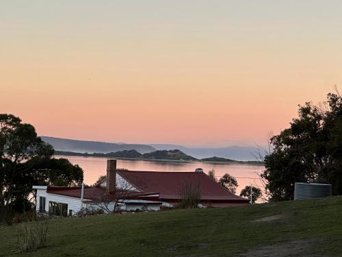a house on a hill with a view of the water at Wylah Cottage for a Peaceful Bruny Island Escape with Water Views, Fireplace & Wallabies in Simpsons Bay