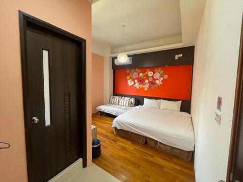 a bedroom with a bed with a red headboard at 198紅帽民宿l市區l2025冷氣全面換新 in Magong