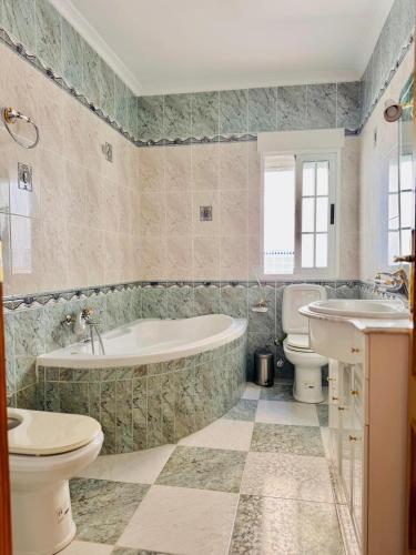a bathroom with a tub and a toilet and a sink at Casa Ramón in Vélez-Rubio