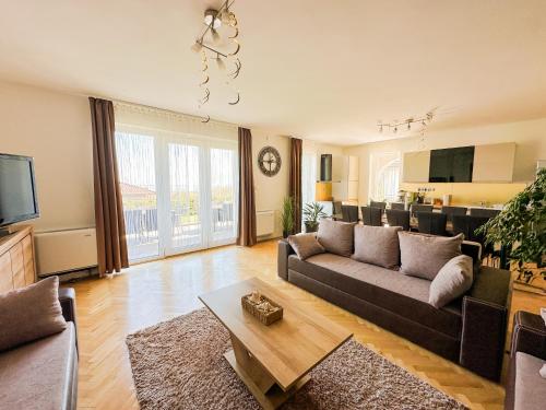 salon z kanapą i stołem w obiekcie Aranyeső Apartmanházak No.1 w mieście Balatonalmádi