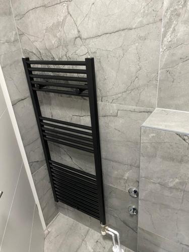 a shower with a black shelf in a bathroom at Nela Apartment in Rabac