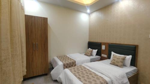 a hotel room with two beds and a closet at Stay Purvi Ganga in Varanasi