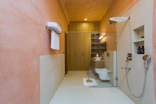 a bathroom with a shower and a toilet at Nature 95 by ELIVAAS 4 BHK Farm with Private Pool in Chandwaji