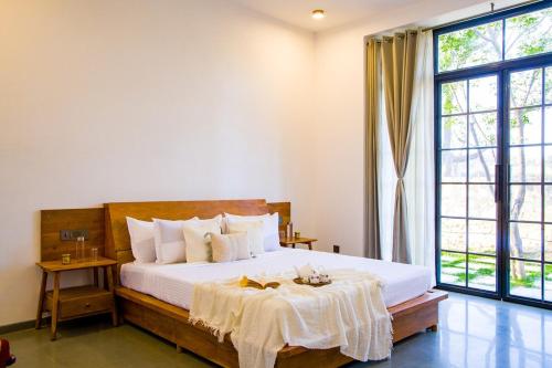 a bedroom with a bed and a large window at Nature 95 by ELIVAAS 4 BHK Farm with Private Pool in Chandwaji