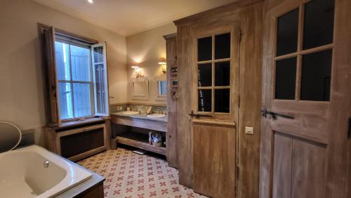 La salle de bains est pourvue d'un lavabo, d'une baignoire et d'une fenêtre. dans l'établissement Comme à la campagne en plein cœur de village, à Fontvieille