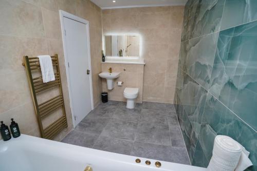 a bathroom with a tub and a toilet and a sink at Park hall Hotel & Spa Lancashire, a member of Radisson Individuals in Eccleston