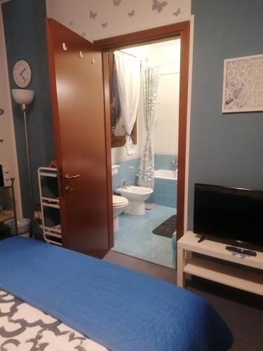 a bedroom with a bathroom with a toilet and a television at La Casa Blu- Forum di Assago, Humanitas, Milanofiori, IEO in Rozzano
