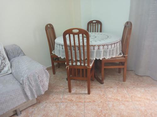 a dining room table and chairs with a table and a bed at Roxy's house in Vlorë