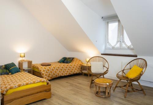 Cette chambre mansardée comprend 2 lits et des chaises. dans l'établissement Neisik Kloz, à Saint-Briac-sur-Mer