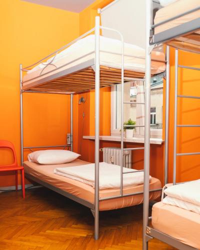 due letti a castello in una stanza con una parete gialla di LazeMaze Hostel a Cracovia