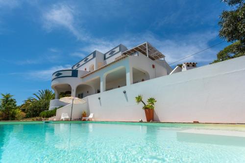 a house with a swimming pool in front of it at Elegant villa, beautiful ocean view, natural paradise! in Tavira