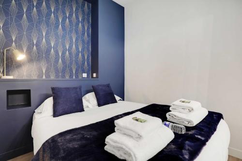 une chambre avec un lit avec des serviettes dessus dans l'établissement Modern Apartment 1BR- 4P Le Marais Quarter, à Paris