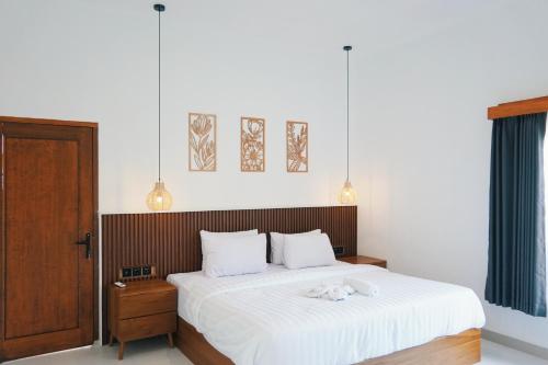 een slaapkamer met een bed met twee knuffels erop bij Villa Calma in Kuta Lombok