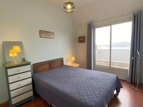 une chambre avec un lit et une grande fenêtre dans l'établissement Appartement à Perros-Guirec proche plage avec balcon et vue mer - FR-1-368-416, à Perros-Guirec