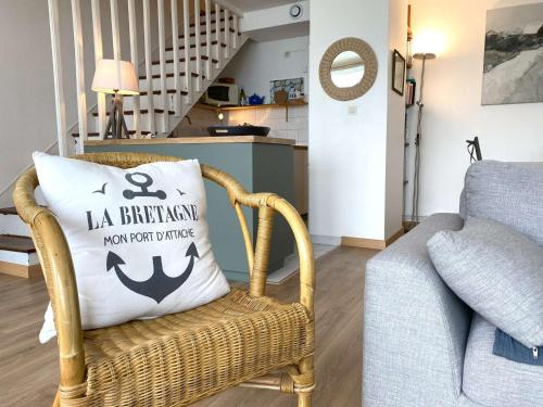- un salon avec une chaise et un oreiller avec une ancre dans l'établissement Appartement à Perros-Guirec proche plage avec balcon et vue mer - FR-1-368-416, à Perros-Guirec
