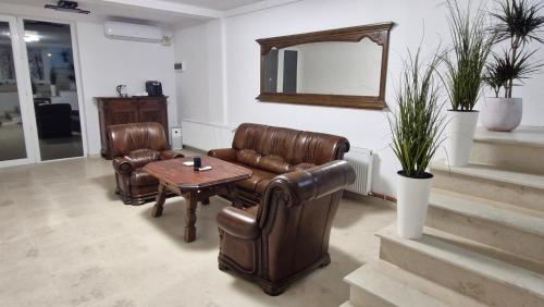 a living room with leather furniture and a mirror at Casa Damian DROBETA in Drobeta-Turnu Severin