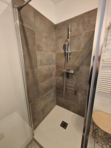 une douche dans une salle de bain avec une porte vitrée dans l'établissement L 'escapade d 'Arvert, à Arvert