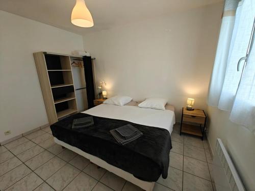 une chambre avec un lit avec deux serviettes dessus dans l'établissement L 'escapade d 'Arvert, à Arvert