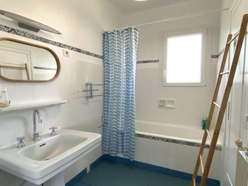 La salle de bains est pourvue d'un lavabo, d'une baignoire et d'une fenêtre. dans l'établissement Maison à 550m de la plage avec jardin, balcon et Wi-Fi à Perros-Guirec - FR-1-368-433, à Perros-Guirec