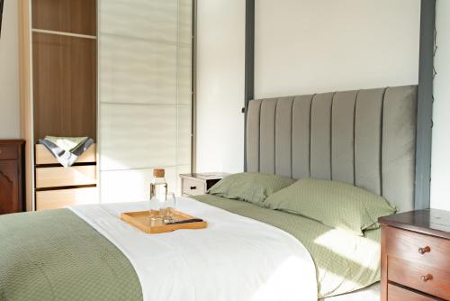 a bedroom with a bed with a wooden tray on it at Unwind 2Bed with Garden, Sauna and Hot Tub in Barking