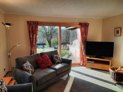 a living room with a couch and a flat screen tv at Maybank in Fort William