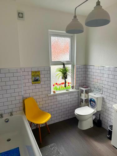 a bathroom with a tub and a toilet and a window at Titanic Shadow - 5 mins from Belfast City Centre in Belfast