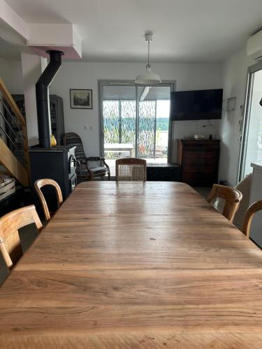 un salon avec une grande table en bois et des chaises dans l'établissement Bienvenue chez Eve en bourgogne, à Beaune
