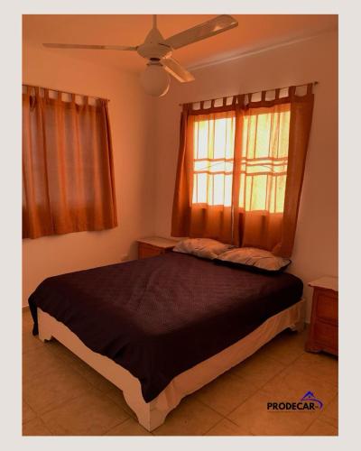 a bedroom with a bed and a window with curtains at apartment for rent in Bayahibe
