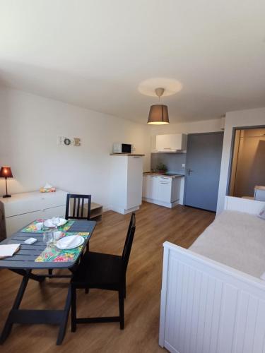 a living room with a table and a bed at Appart' Islande in Le Château-dʼOléron