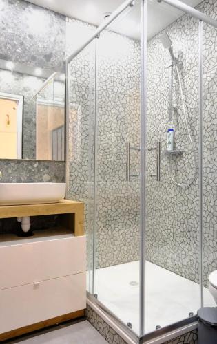 La salle de bains est pourvue d'une douche avec des portes en verre. dans l'établissement La Cachette du Panier à Marseille, à Marseille