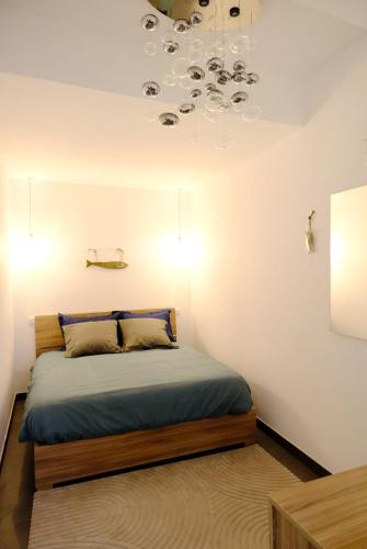 une chambre avec un lit et un lustre dans l'établissement La Cachette du Panier à Marseille, à Marseille