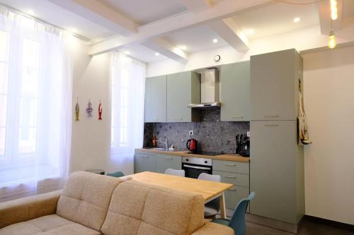 un salon avec une table et une cuisine dans l'établissement La Cachette du Panier à Marseille, à Marseille
