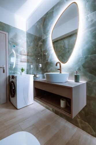 a bathroom with a sink and a mirror at Esperides Luxury Suites 1 in Kalamitsi