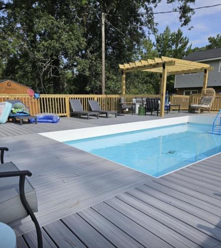 a swimming pool on a wooden deck with a gazebo at Cardinal Seas home in Morehead City