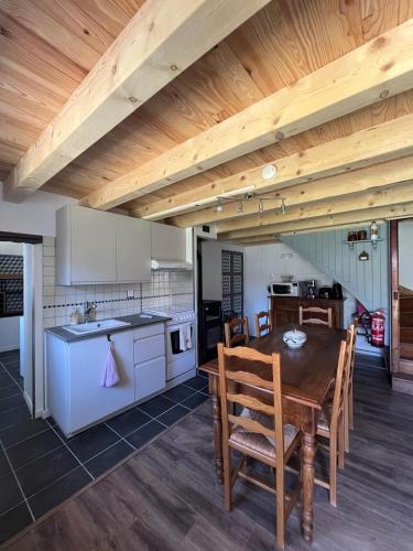a kitchen and dining room with a wooden ceiling at Chez Maria in Corbel