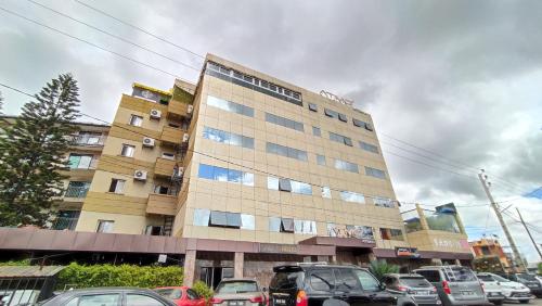 a tall building with cars parked in a parking lot at Atmosphere Hotel & Spa in Antananarivo