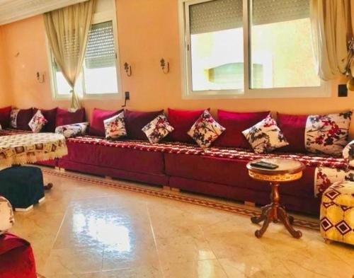 een woonkamer met een rode bank met kussens bij Apartamento hay amal 12 in Sale