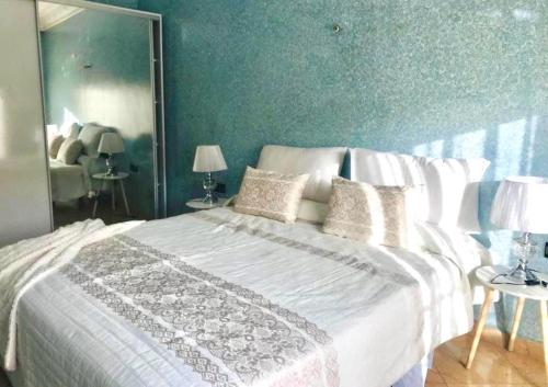 een slaapkamer met een groot wit bed en een groene muur bij Apartamento hay amal 12 in Sale