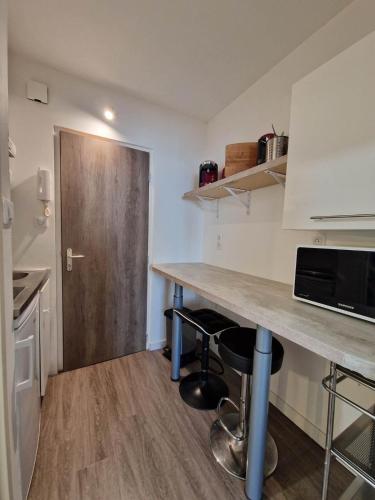 - une cuisine avec un comptoir et une porte en bois dans l'établissement Ty Cosy beau studio en centre-ville proche mer, à Concarneau