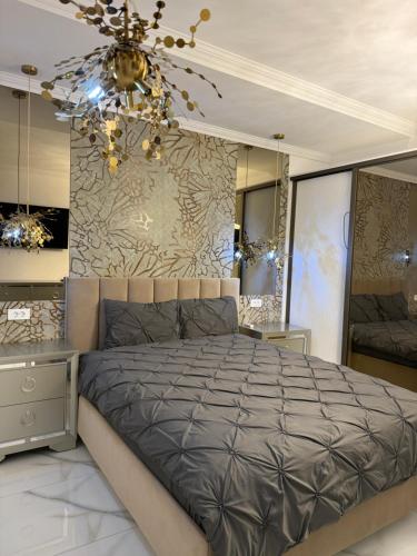 a bedroom with a large bed and a chandelier at VILA Neptun Jacuzi SPA in Săcele